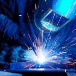 Welder erecting technical steel. Industrial steel welder in factory technical